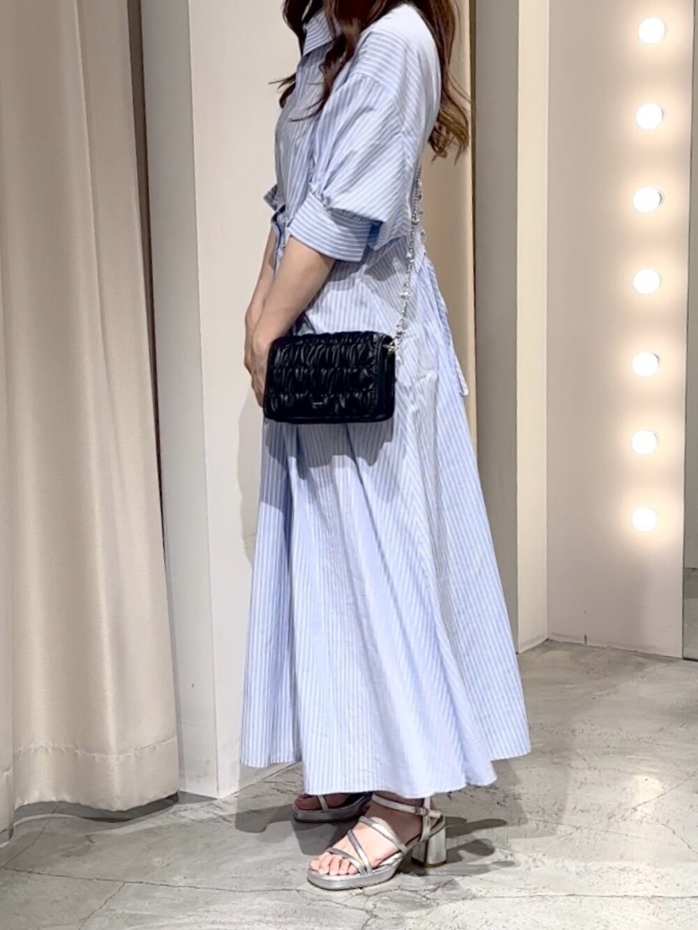 ブルー系のワンピース、ブラック系のショルダーバッグ、シルバー系のシューズを着用したレディースの夏コーディネートの7枚目の写真