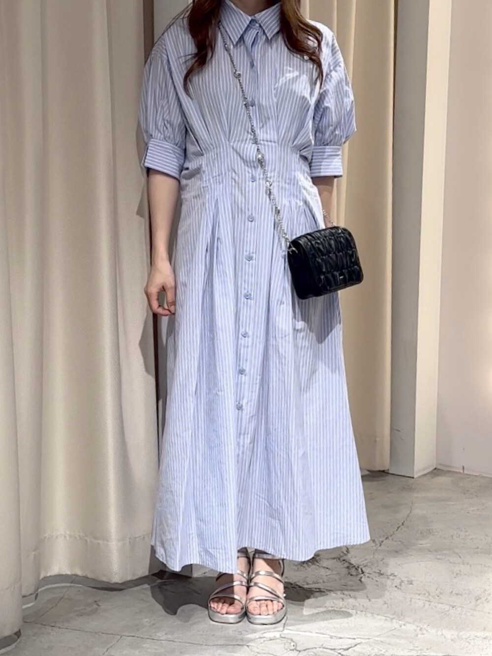 ブルー系のワンピース、ブラック系のショルダーバッグ、シルバー系のシューズを着用したレディースの夏コーディネートの6枚目の写真