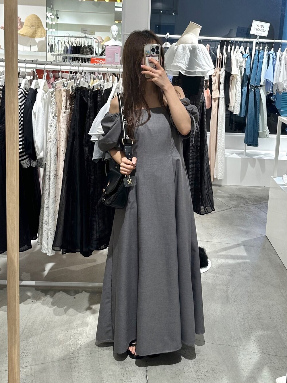 ブラック系のショルダーバッグ、グレー系のワンピースを着用したレディースの夏コーディネートの2枚目の写真