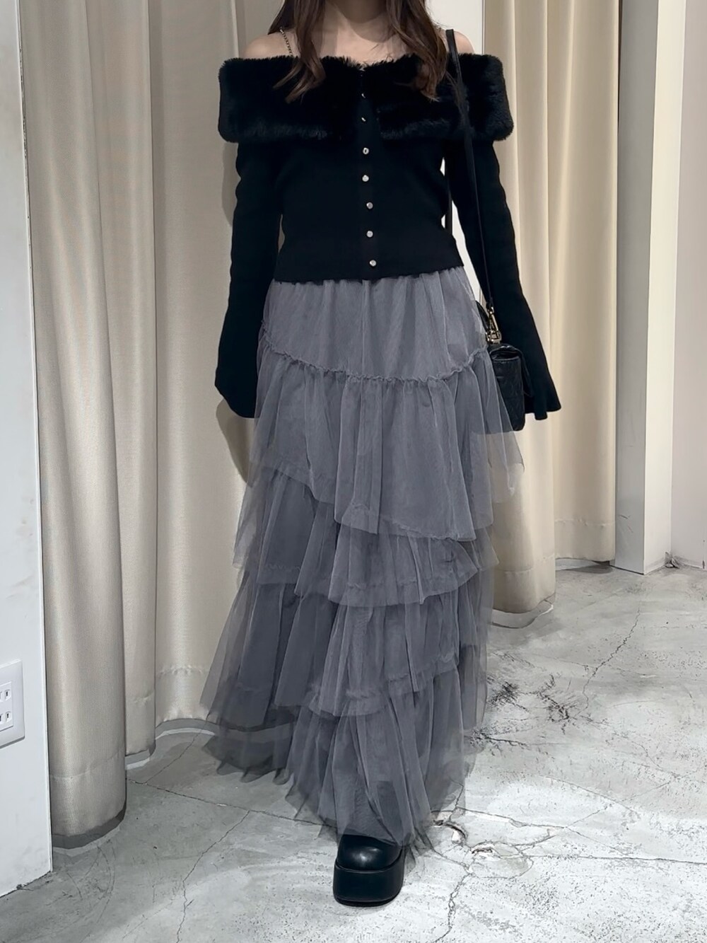 ブラック系のブーツ、グレー系のスカート、ブラック系のニット/セーターを着用したレディースの冬コーディネートの7枚目の写真