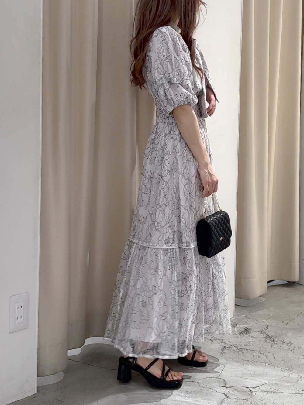 ホワイト系のワンピース/ドレス、ブラック系のサンダルを着用したレディースの春コーディネートの4枚目の写真