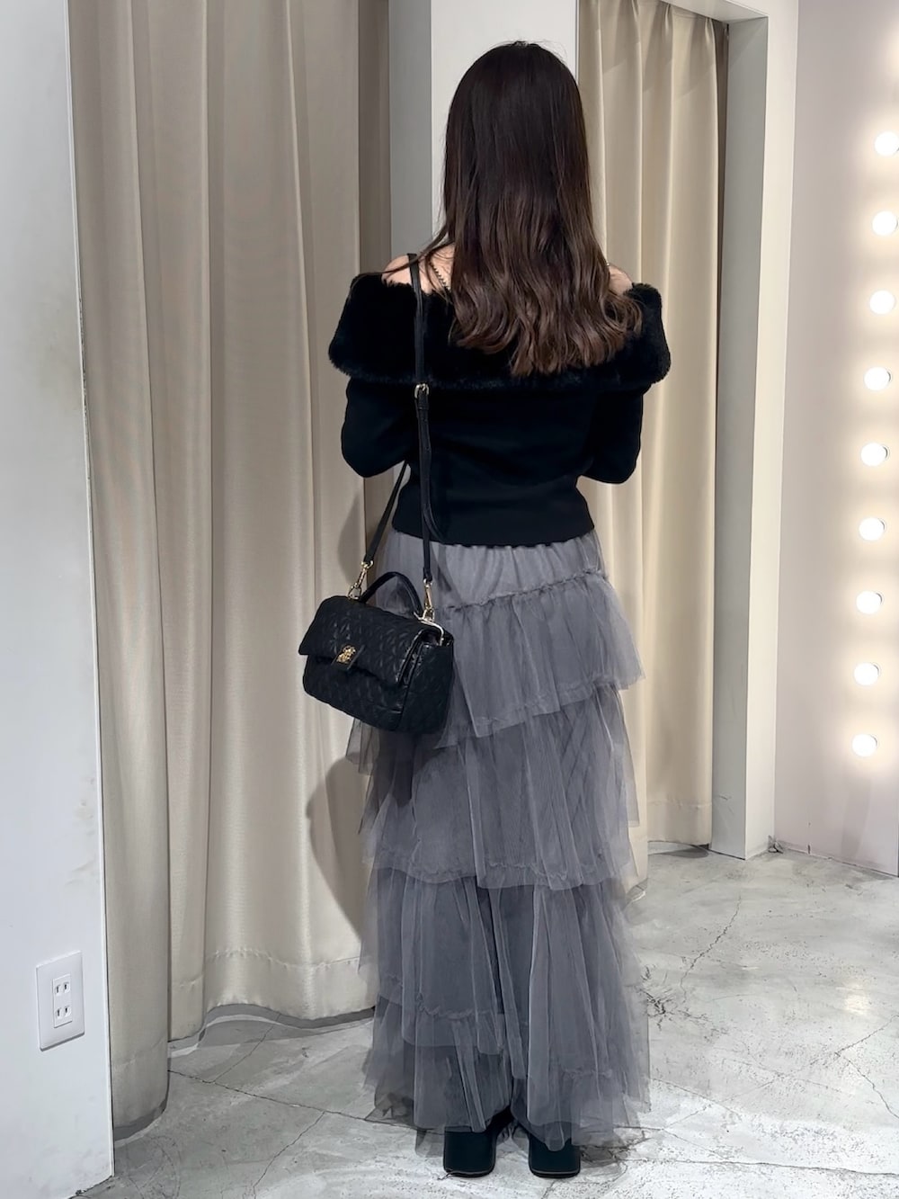 ブラック系のブーツ、グレー系のスカート、ブラック系のニット/セーターを着用したレディースの冬コーディネートの8枚目の写真