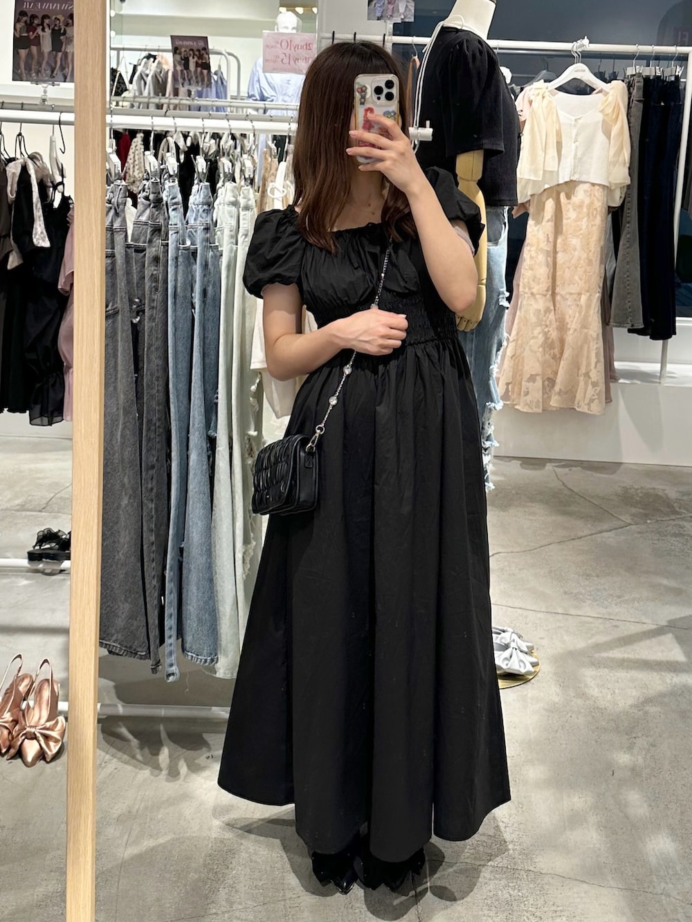 ブラック系のワンピース、ブラック系のパンプス、ブラック系のショルダーバッグを着用したレディースの夏コーディネートの7枚目の写真