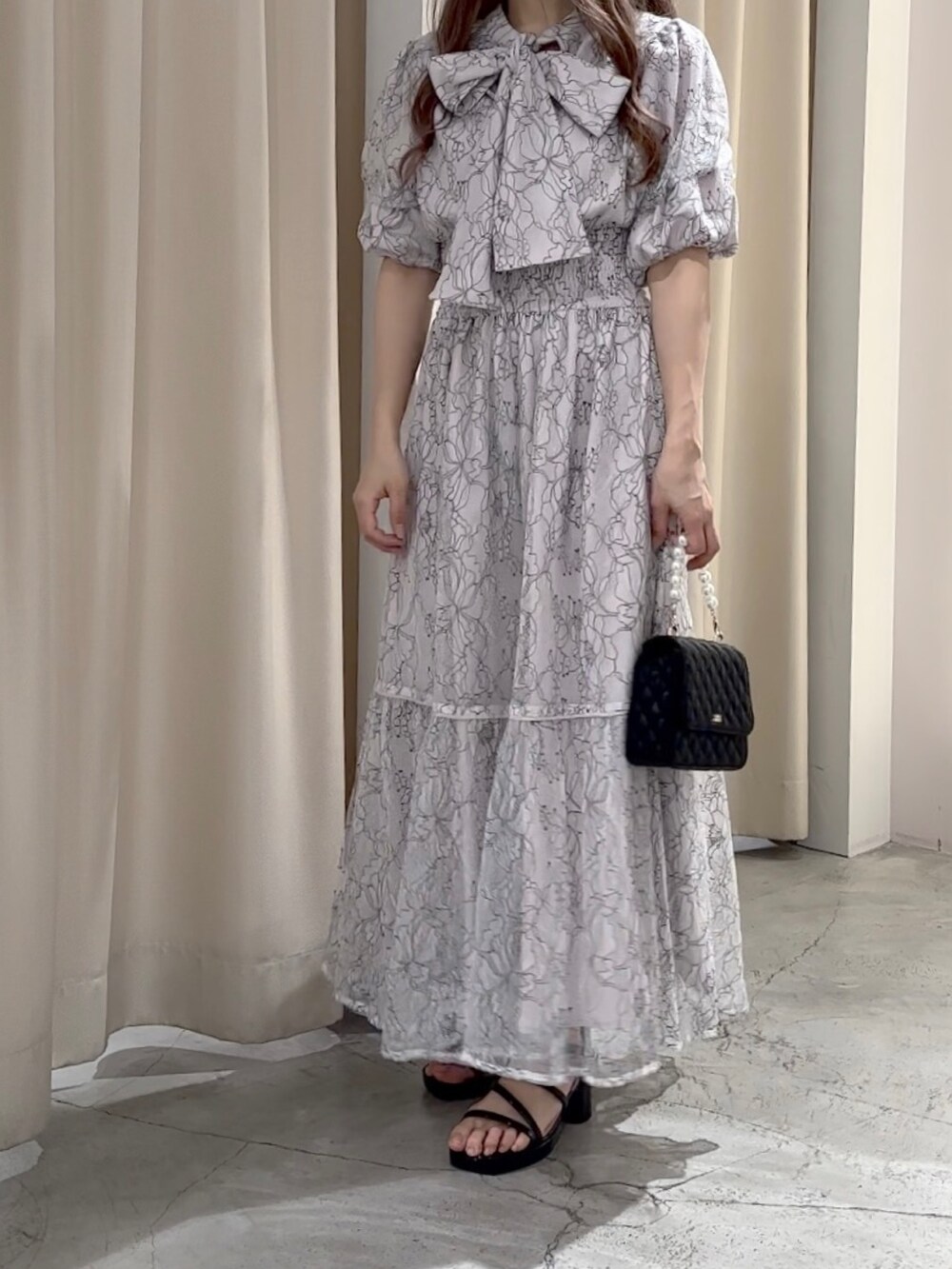 ホワイト系のワンピース/ドレス、ブラック系のサンダルを着用したレディースの春コーディネートの3枚目の写真