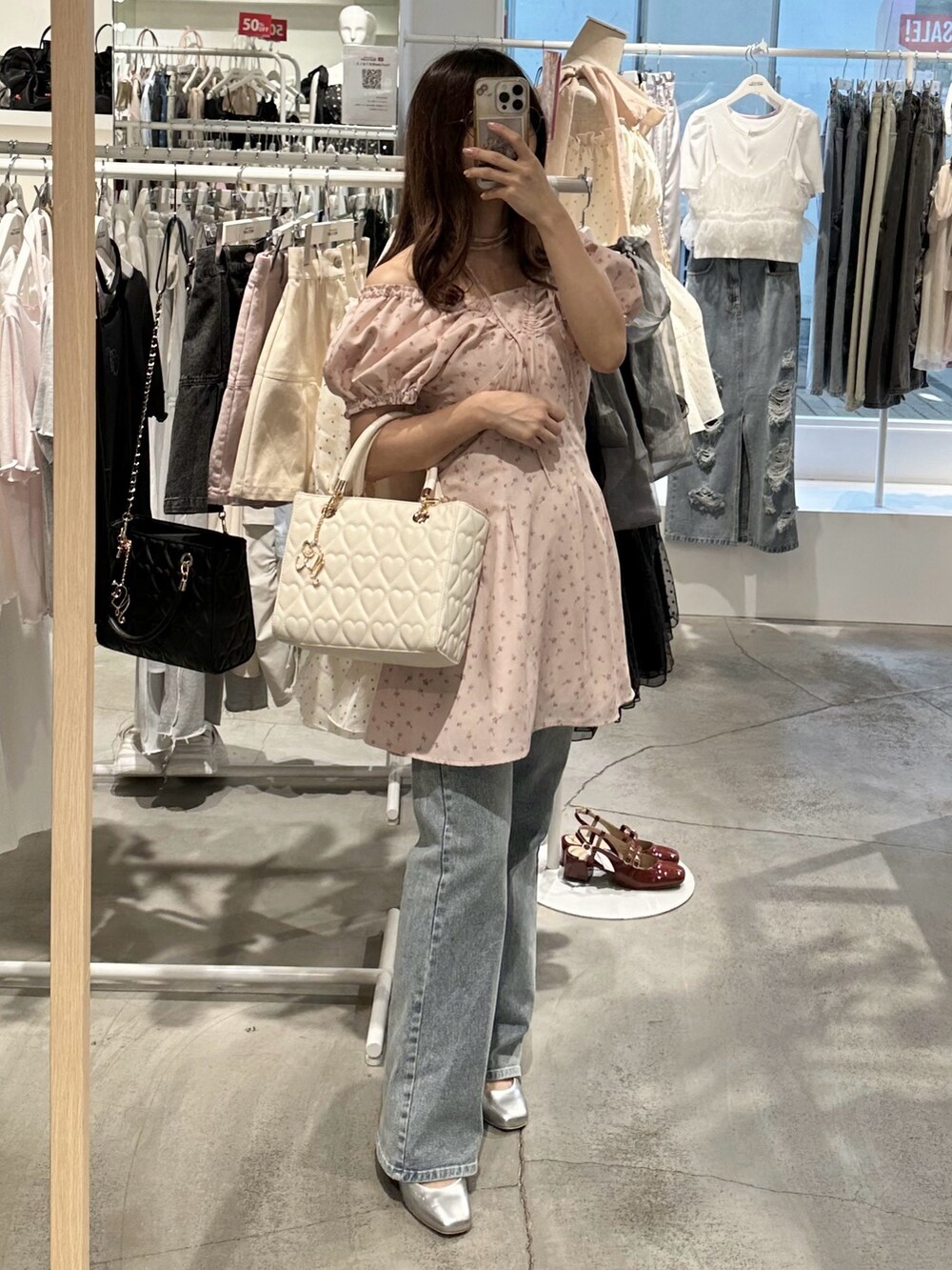 ピンク系のワンピース、ブルー系のデニムパンツ、シルバー系のパンプスを着用したレディースの夏コーディネートの10枚目の写真