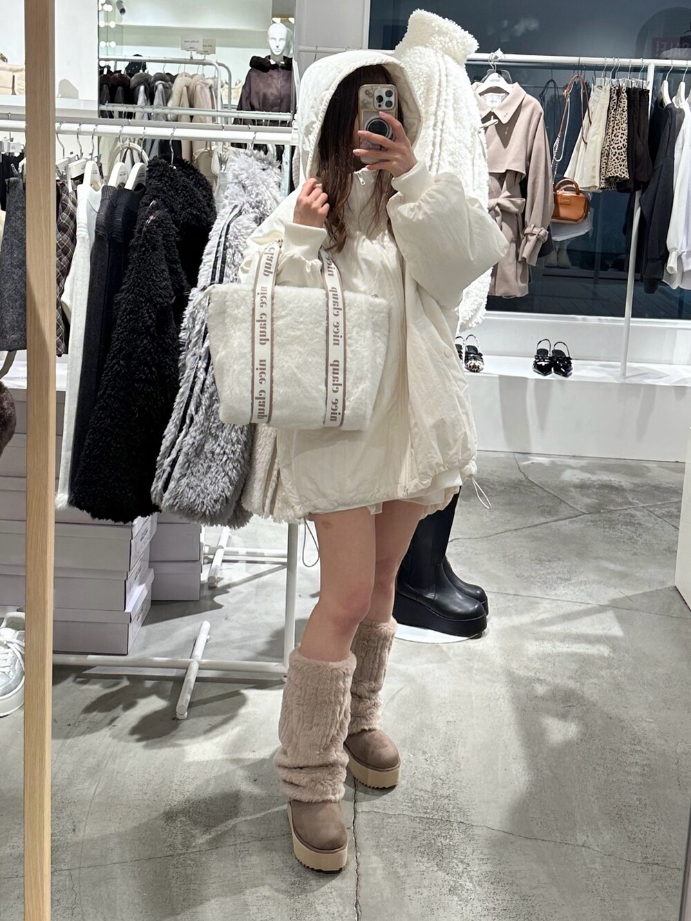 ブラウン系のブーツ、ホワイト系のブルゾンを着用したレディースの冬コーディネートの3枚目の写真