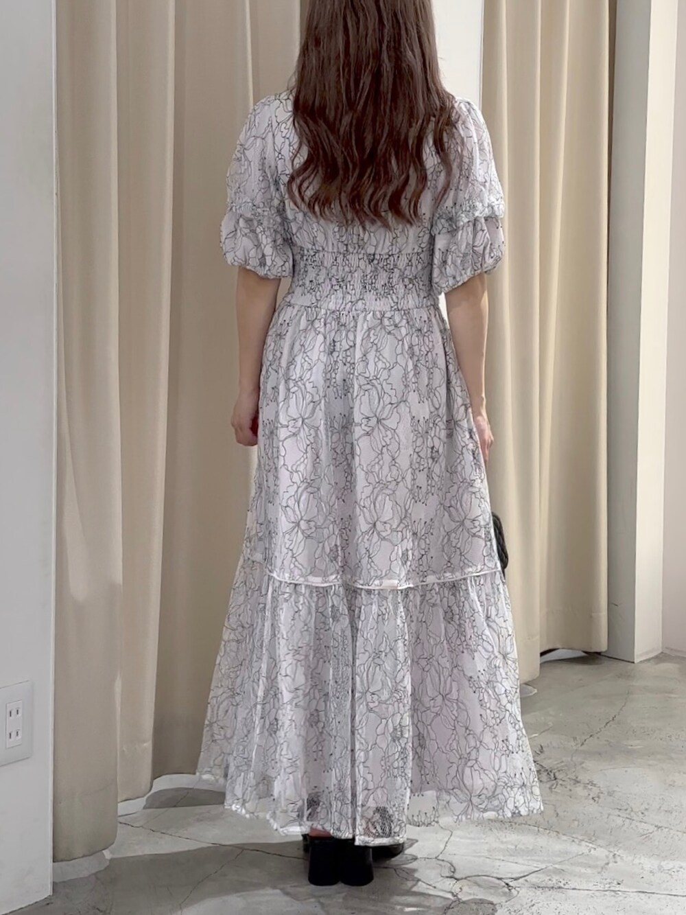 ホワイト系のワンピース/ドレス、ブラック系のサンダルを着用したレディースの春コーディネートの6枚目の写真