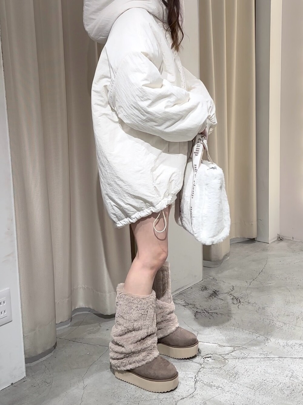 ブラウン系のブーツ、ホワイト系のブルゾンを着用したレディースの冬コーディネートの7枚目の写真