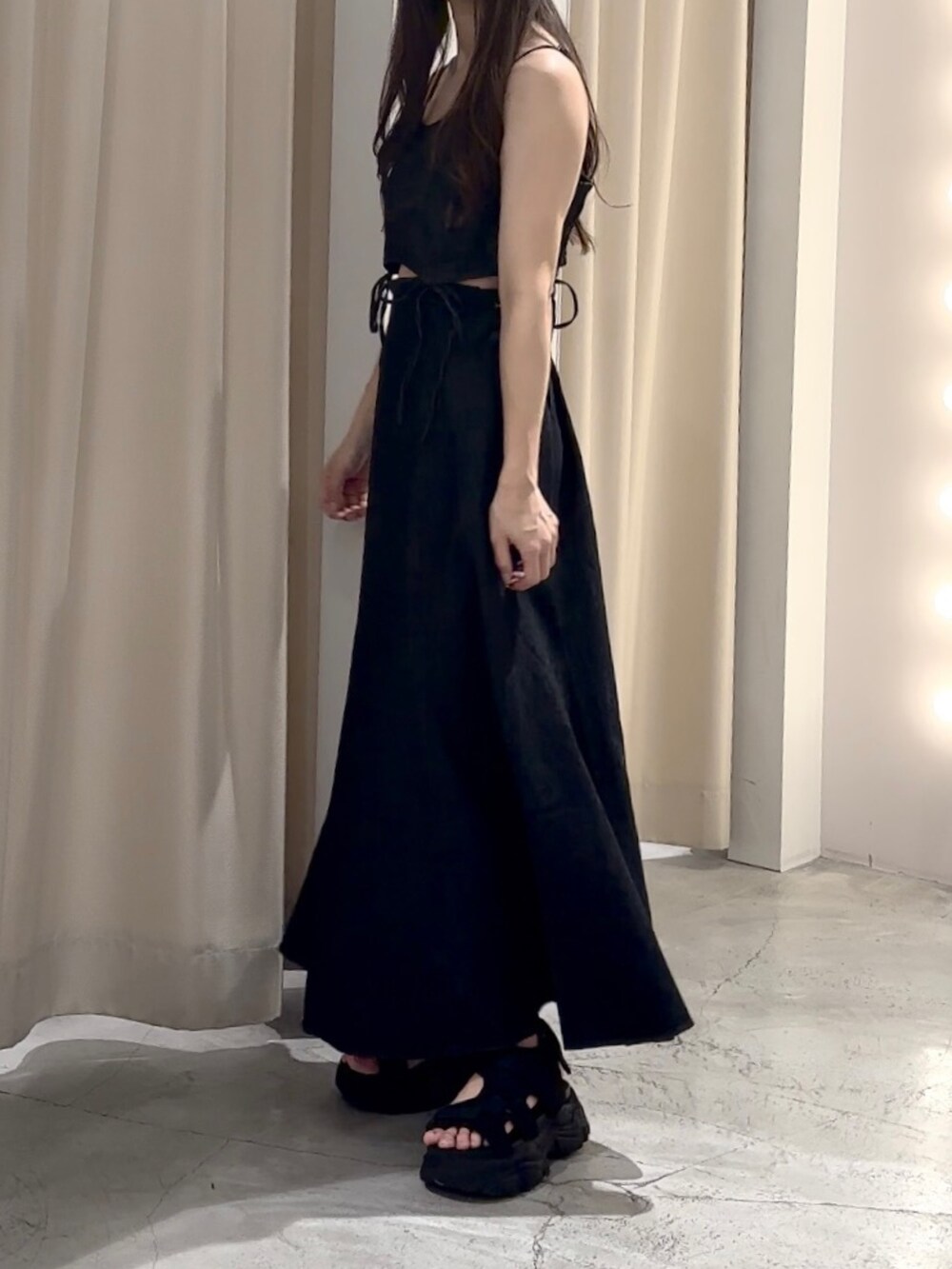 ブラック系のワンピースを着用したレディースの夏コーディネートの2枚目の写真