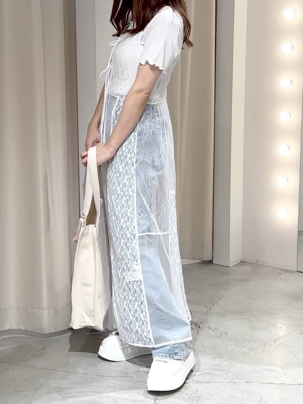 ホワイト系のワンピース、ブルー系のデニムパンツ、ホワイト系のトートバッグを着用したレディースの夏コーディネートの5枚目の写真