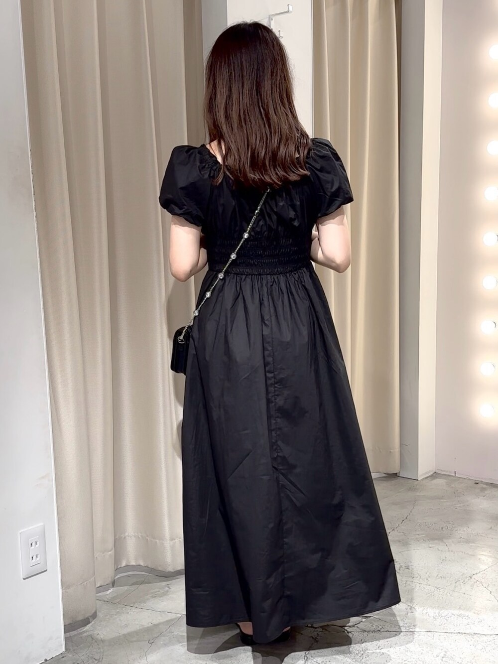 ブラック系のワンピース、ブラック系のパンプス、ブラック系のショルダーバッグを着用したレディースの夏コーディネートの9枚目の写真