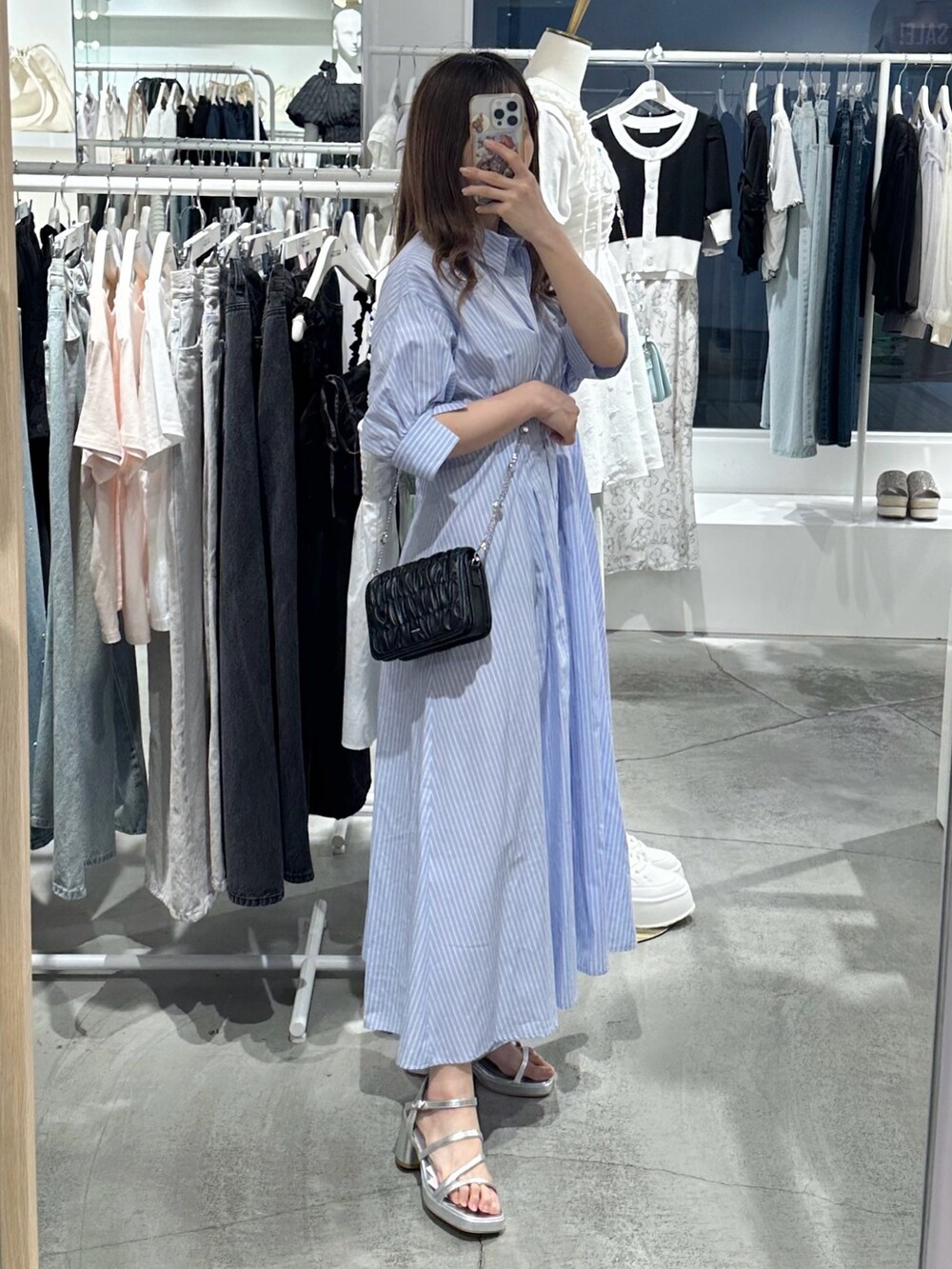 ブルー系のワンピース、ブラック系のショルダーバッグ、シルバー系のシューズを着用したレディースの夏コーディネートの4枚目の写真