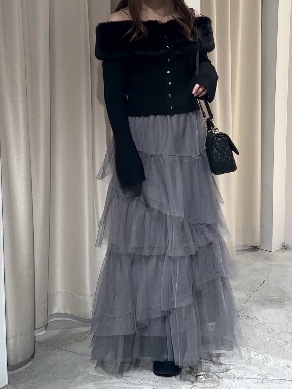 ブラック系のブーツ、グレー系のスカート、ブラック系のニット/セーターを着用したレディースの冬コーディネートの4枚目の写真