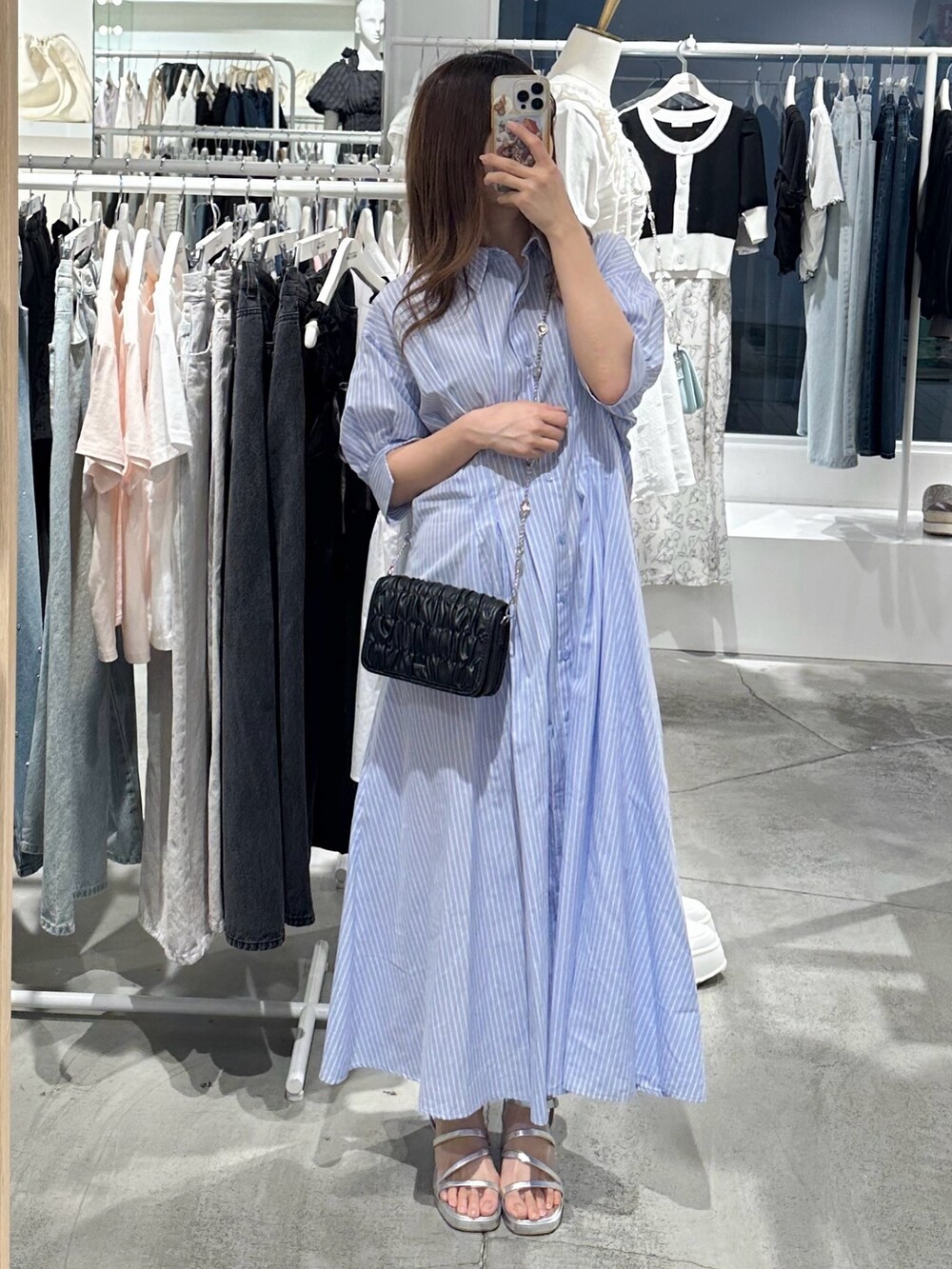 ブルー系のワンピース、ブラック系のショルダーバッグ、シルバー系のシューズを着用したレディースの夏コーディネートの2枚目の写真