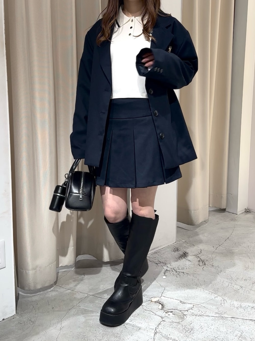 ブルー系のスカート、ブルー系のテーラードジャケット、ホワイト系のニット/セーターを着用したレディースの冬コーディネートの3枚目の写真