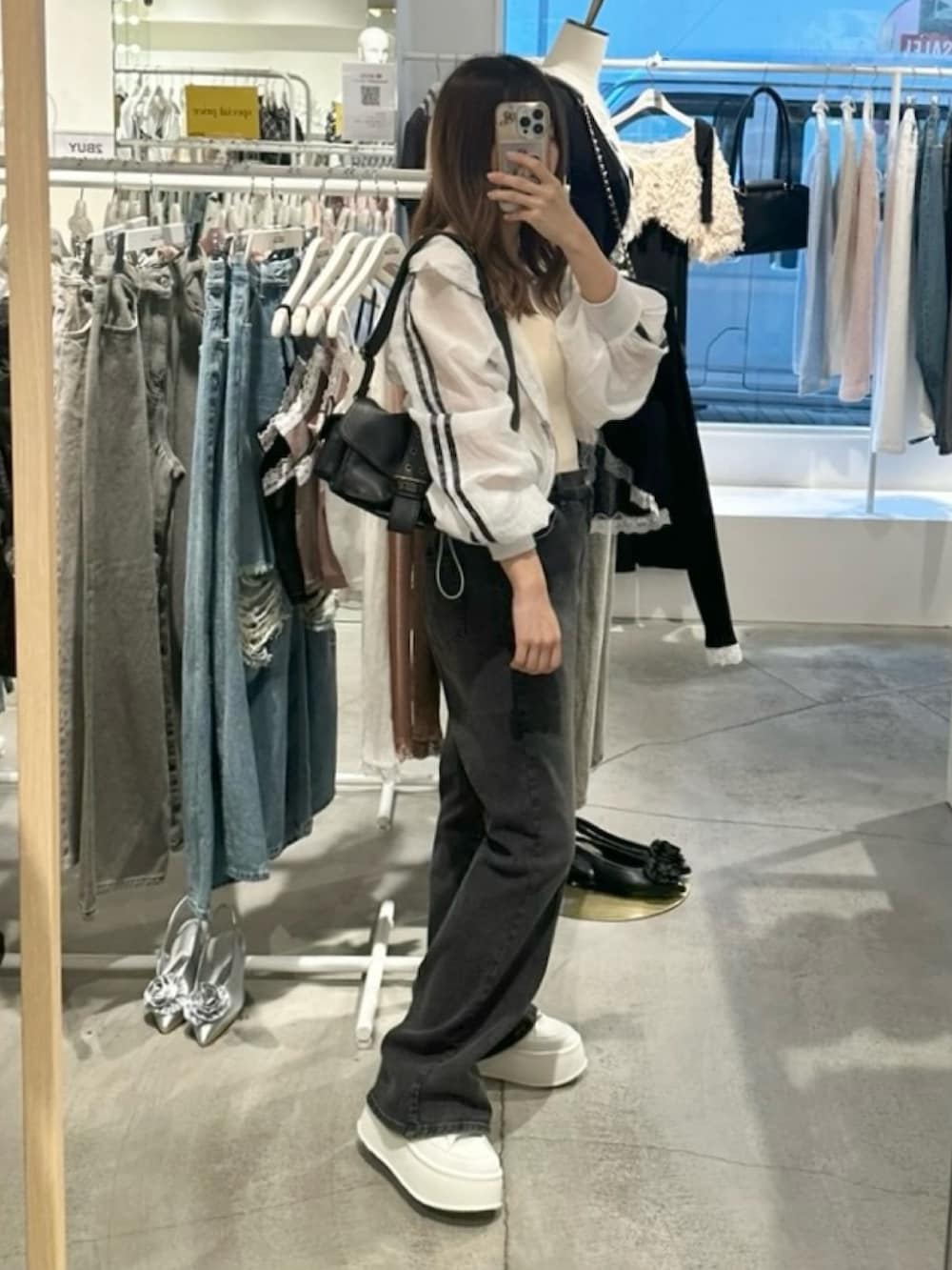 ホワイト系のブルゾン、ホワイト系のキャミソール、グレー系のデニムパンツを着用したレディースの夏コーディネートの4枚目の写真