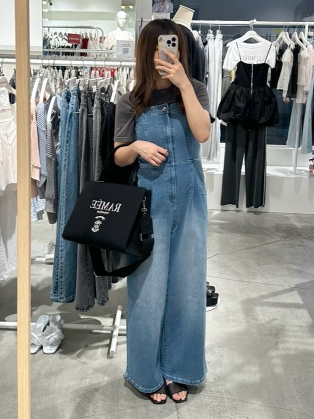 ブルー系のサロペット/オーバーオール、ブラック系のTシャツ/カットソー、ブラック系のサンダルを着用したレディースの夏コーディネートの4枚目の写真