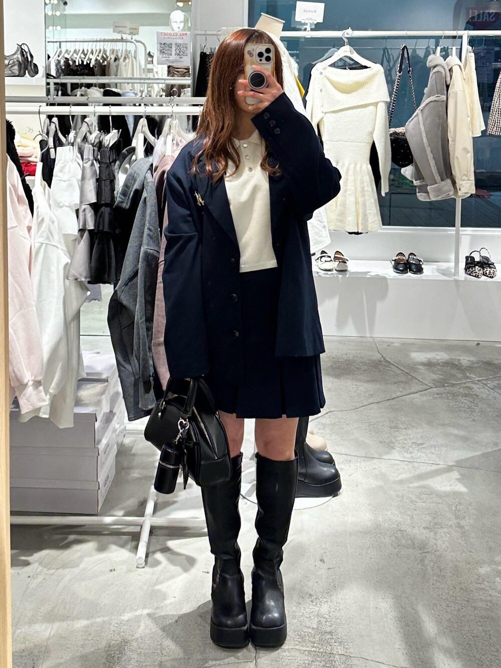 ブルー系のスカート、ブルー系のテーラードジャケット、ホワイト系のニット/セーターを着用したレディースの冬コーディネートの2枚目の写真