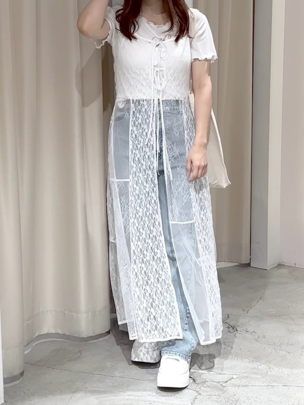 ホワイト系のワンピース、ブルー系のデニムパンツ、ホワイト系のトートバッグを着用したレディースの夏コーディネートの3枚目の写真