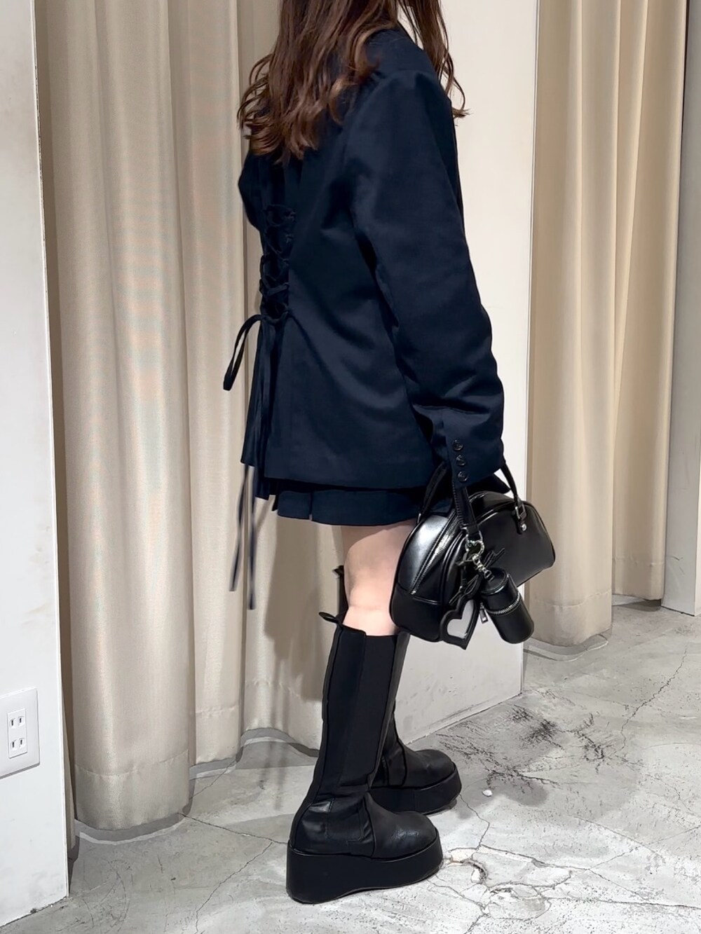 ブルー系のスカート、ブルー系のテーラードジャケット、ホワイト系のニット/セーターを着用したレディースの冬コーディネートの4枚目の写真