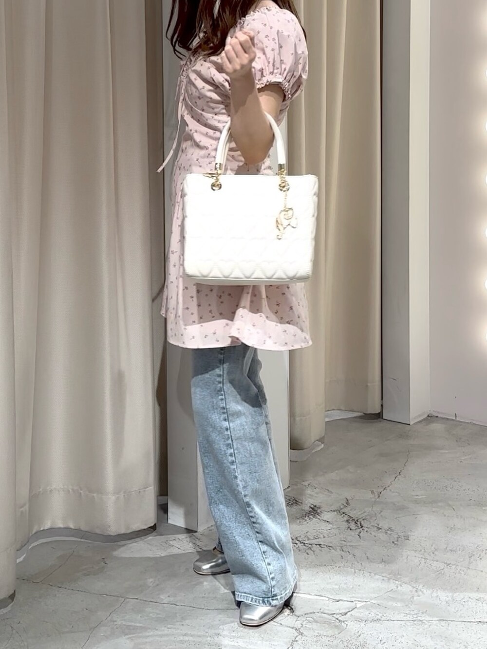 ピンク系のワンピース、ブルー系のデニムパンツ、シルバー系のパンプスを着用したレディースの夏コーディネートの2枚目の写真