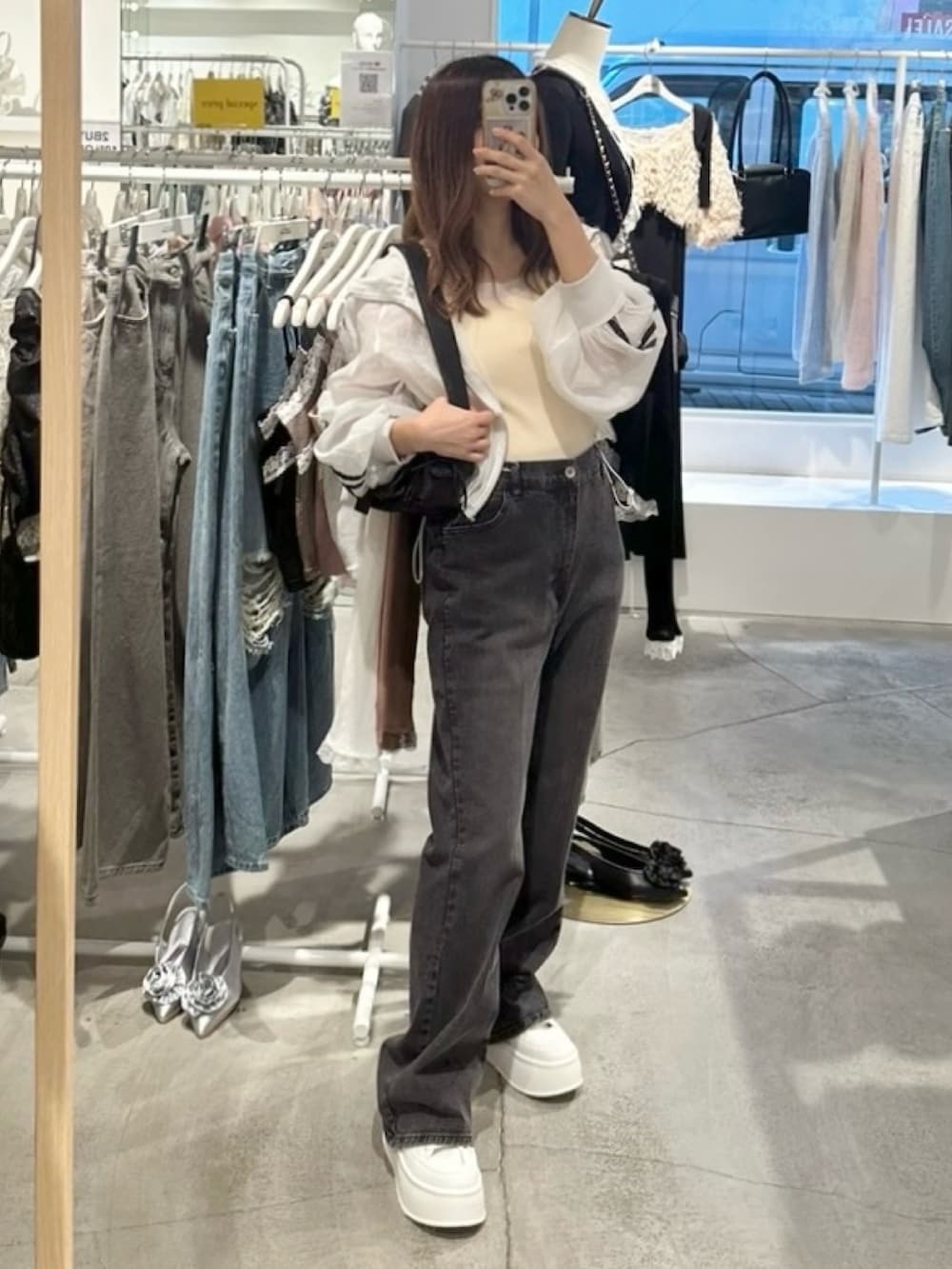 ホワイト系のブルゾン、ホワイト系のキャミソール、グレー系のデニムパンツを着用したレディースの夏コーディネートの5枚目の写真