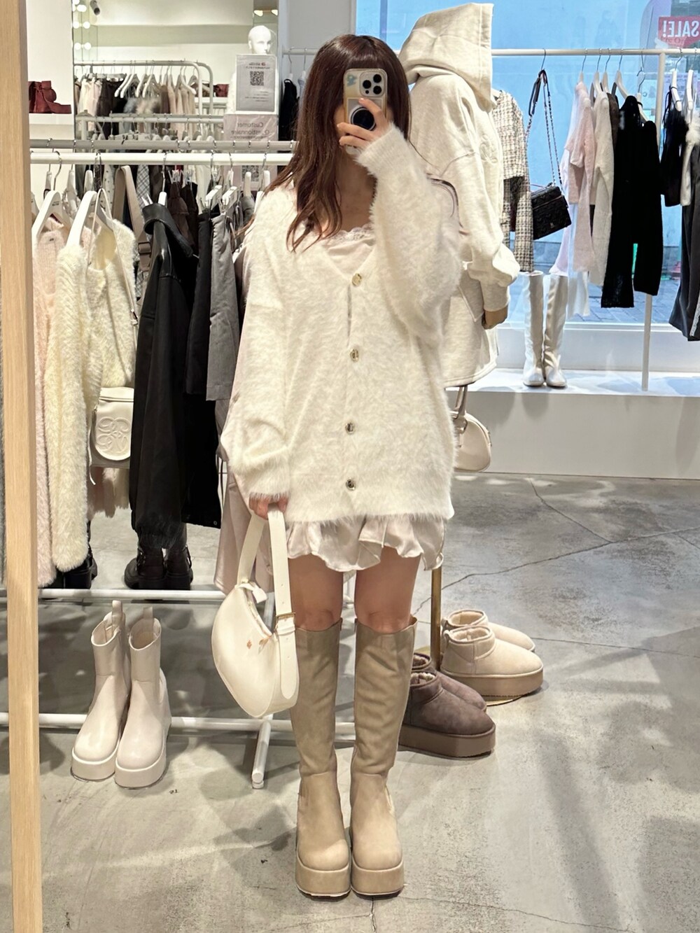 ホワイト系のカーディガン/ボレロ、ベージュ系のブーツ、ホワイト系のショルダーバッグを着用したレディースの秋コーディネートの9枚目の写真