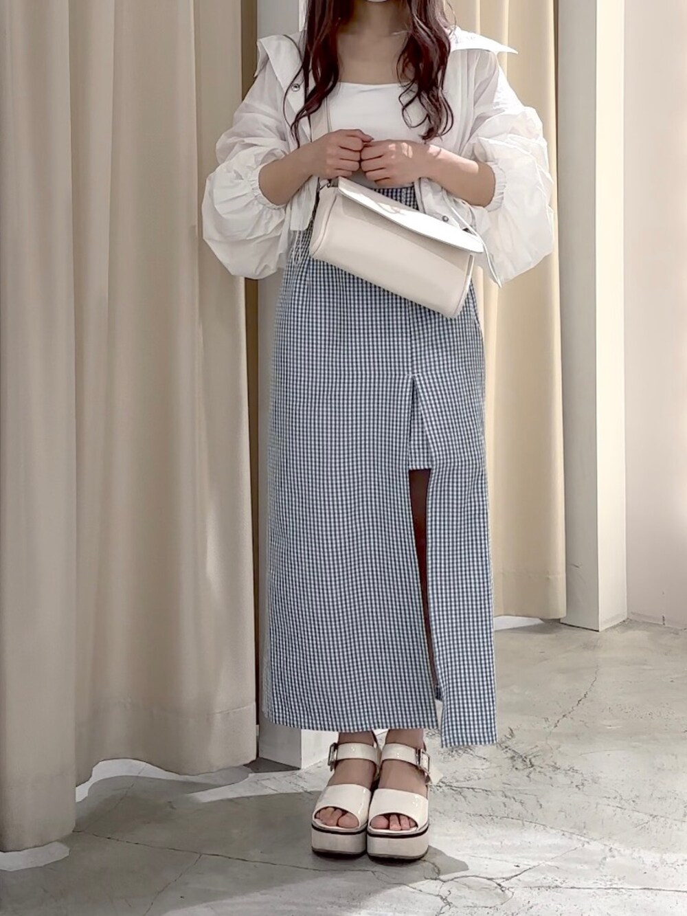 ホワイト系のマウンテンパーカー、ホワイト系のキャミソール、ホワイト系のボディバッグ/ウエストポーチを着用したレディースの春コーディネートの4枚目の写真