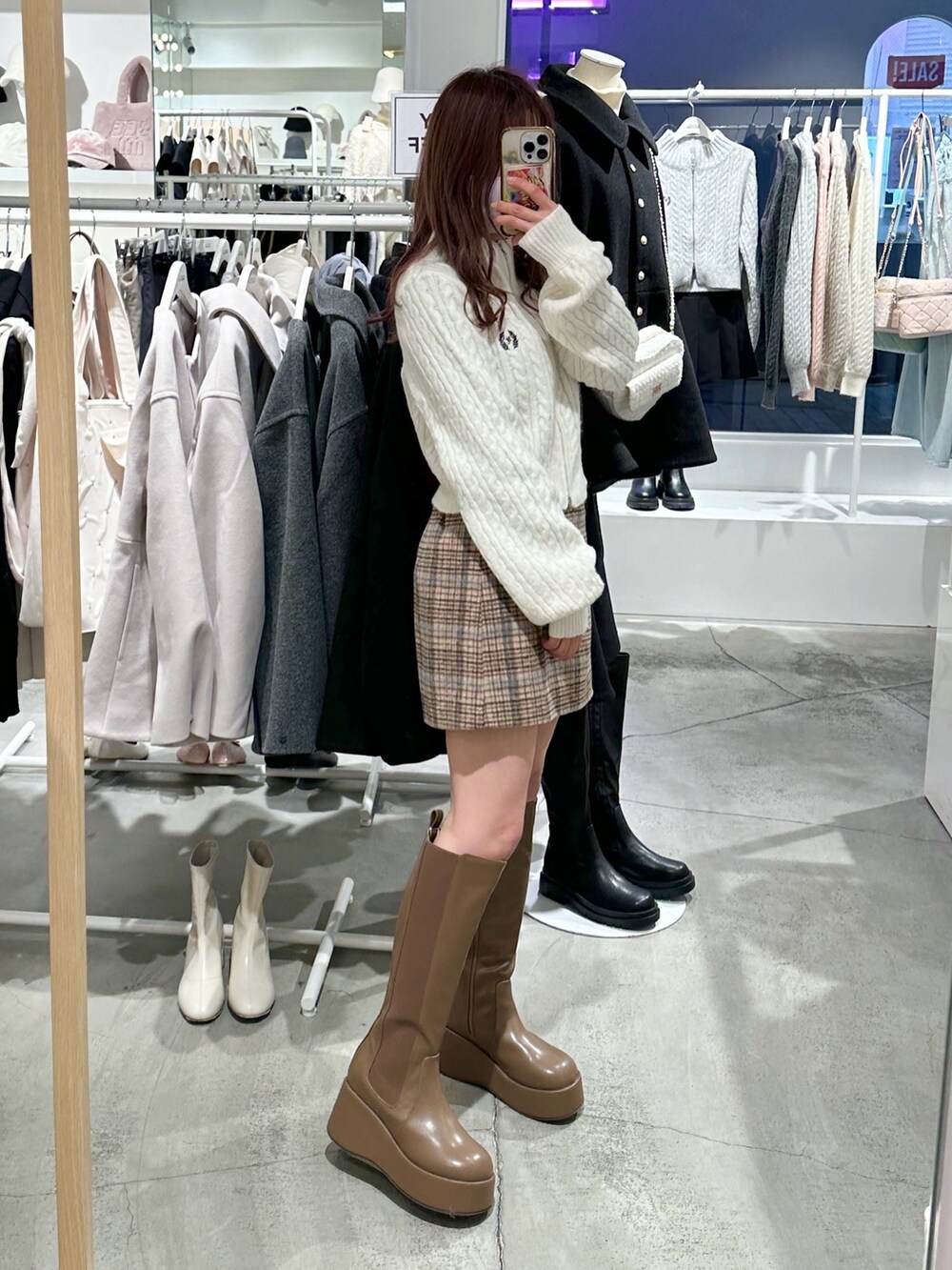 ホワイト系のニット/セーター、ベージュ系のスカート、ブラウン系のブーツを着用したレディースの冬コーディネートの4枚目の写真