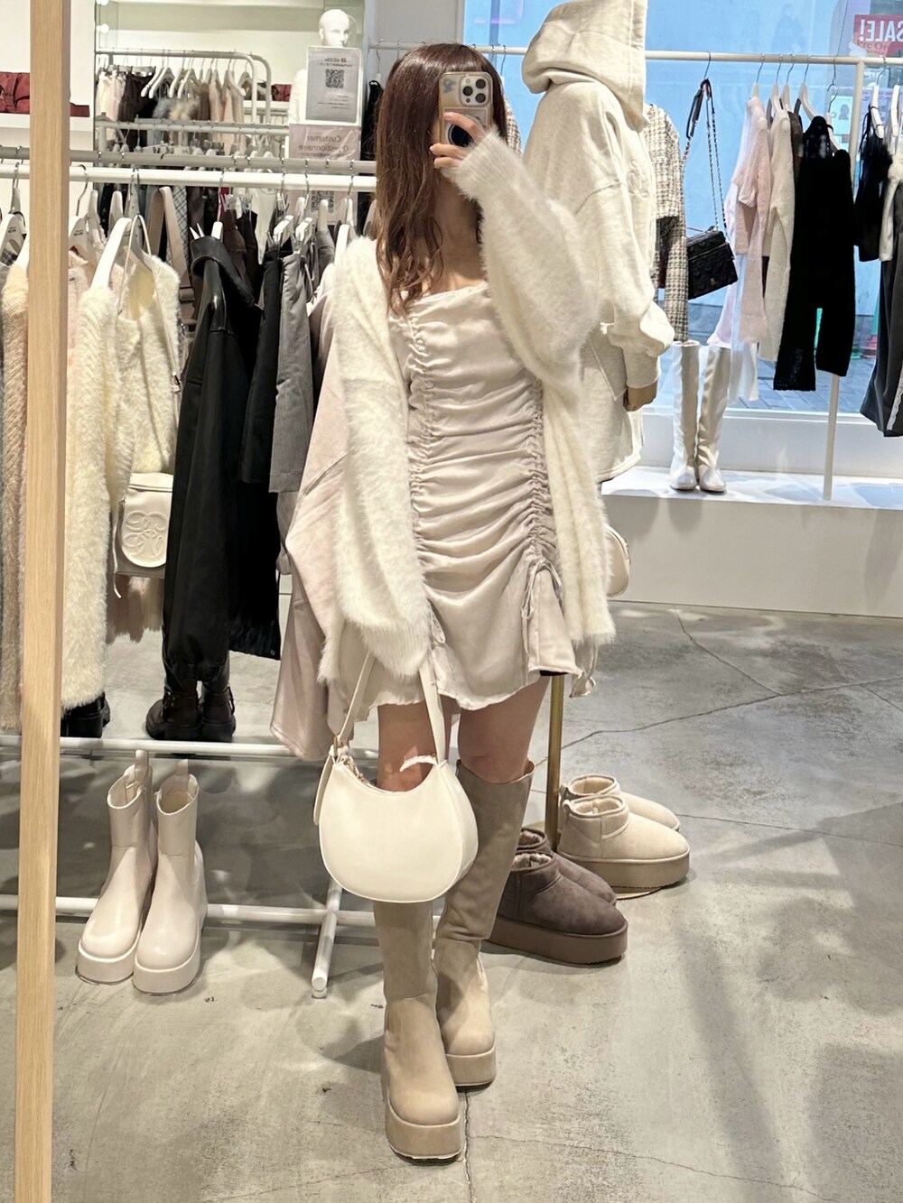 ホワイト系のカーディガン/ボレロ、ベージュ系のブーツ、ホワイト系のショルダーバッグを着用したレディースの秋コーディネートの3枚目の写真