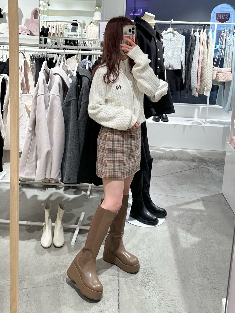 ホワイト系のニット/セーター、ベージュ系のスカート、ブラウン系のブーツを着用したレディースの冬コーディネートの3枚目の写真