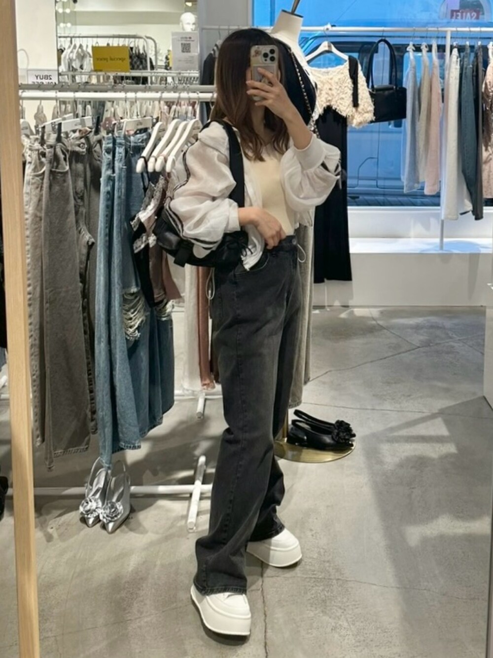 ホワイト系のブルゾン、ホワイト系のキャミソール、グレー系のデニムパンツを着用したレディースの夏コーディネートの3枚目の写真