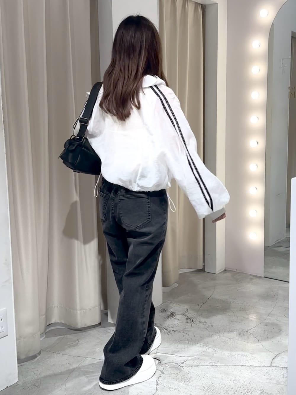 ホワイト系のブルゾン、ホワイト系のキャミソール、グレー系のデニムパンツを着用したレディースの夏コーディネートの8枚目の写真