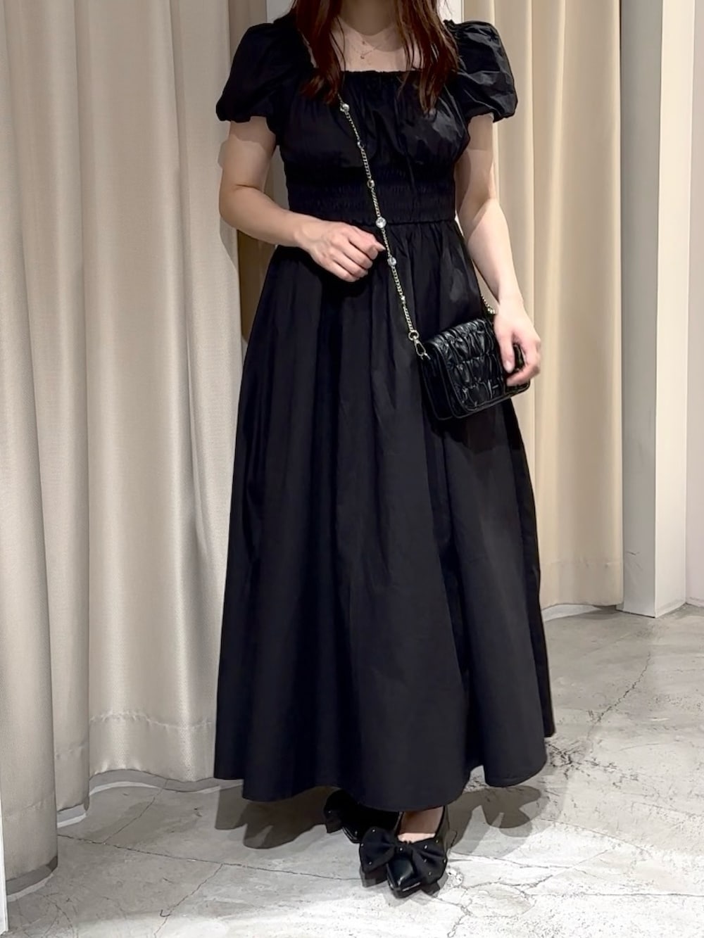 ブラック系のワンピース、ブラック系のパンプス、ブラック系のショルダーバッグを着用したレディースの夏コーディネートの5枚目の写真