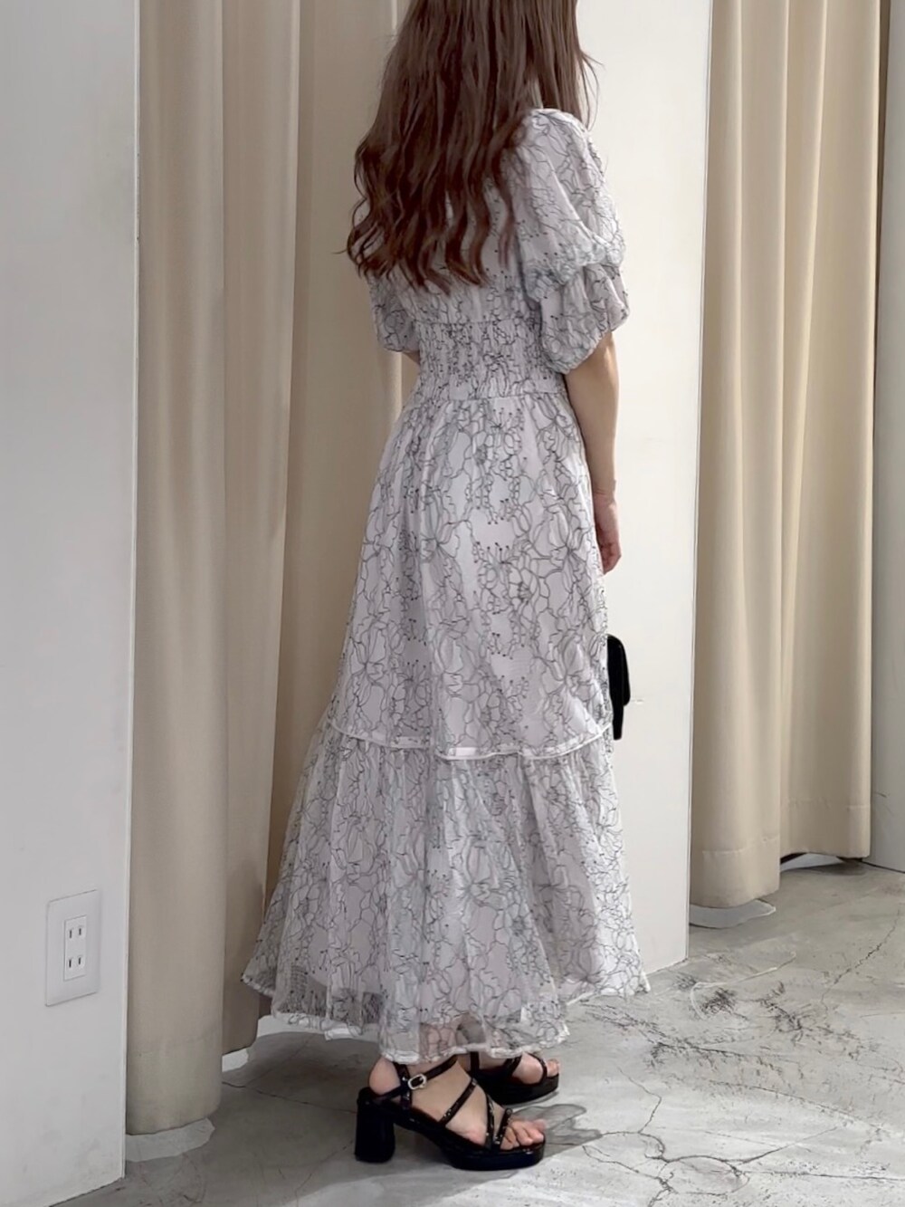 ホワイト系のワンピース/ドレス、ブラック系のサンダルを着用したレディースの春コーディネートの5枚目の写真