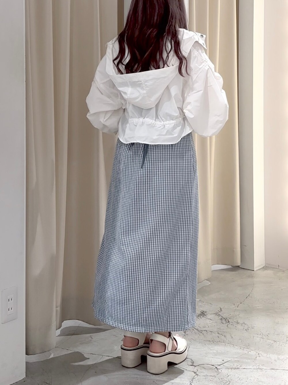 ホワイト系のマウンテンパーカー、ホワイト系のキャミソール、ホワイト系のボディバッグ/ウエストポーチを着用したレディースの春コーディネートの6枚目の写真