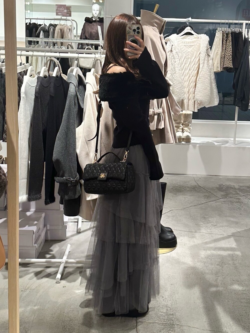 ブラック系のブーツ、グレー系のスカート、ブラック系のニット/セーターを着用したレディースの冬コーディネートの3枚目の写真