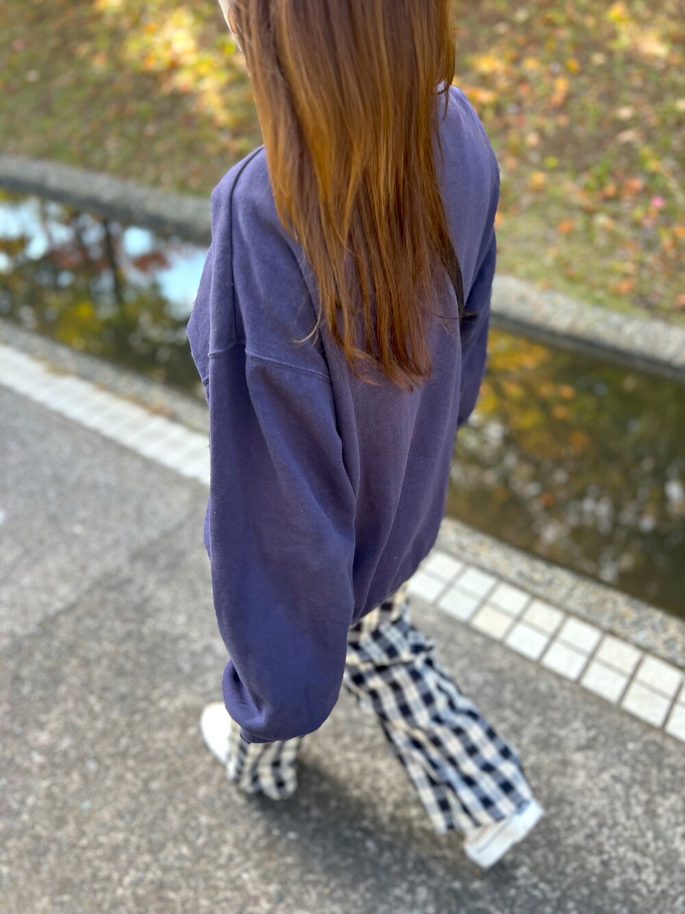 ブルー系のスウェット、ベージュ系のその他パンツ、ホワイト系のスニーカーを着用したレディースの秋コーディネートの2枚目の写真