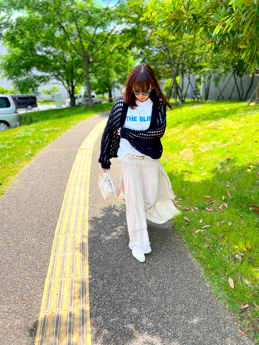 ホワイト系のTシャツ/カットソー、ブラック系のカーディガン/ボレロ、ホワイト系のショルダーバッグを着用したレディースの春コーディネートの2枚目の写真