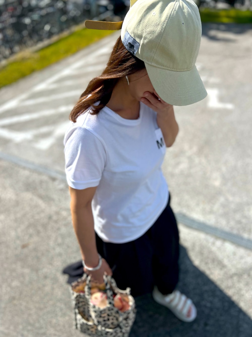 ホワイト系のサンダル、ブラック系のスカート、ホワイト系のTシャツ/カットソーを着用したレディースの夏コーディネートの4枚目の写真