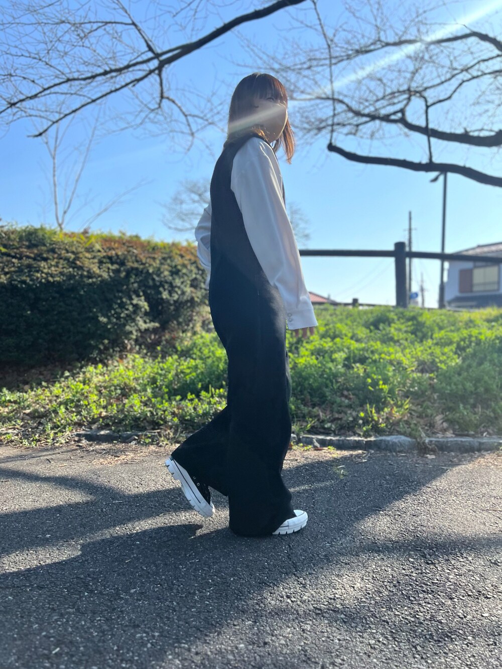 ブルー系のデニムジャケット、ホワイト系のシャツ/ブラウス、ブラック系のスニーカーを着用したレディースの春コーディネートの2枚目の写真