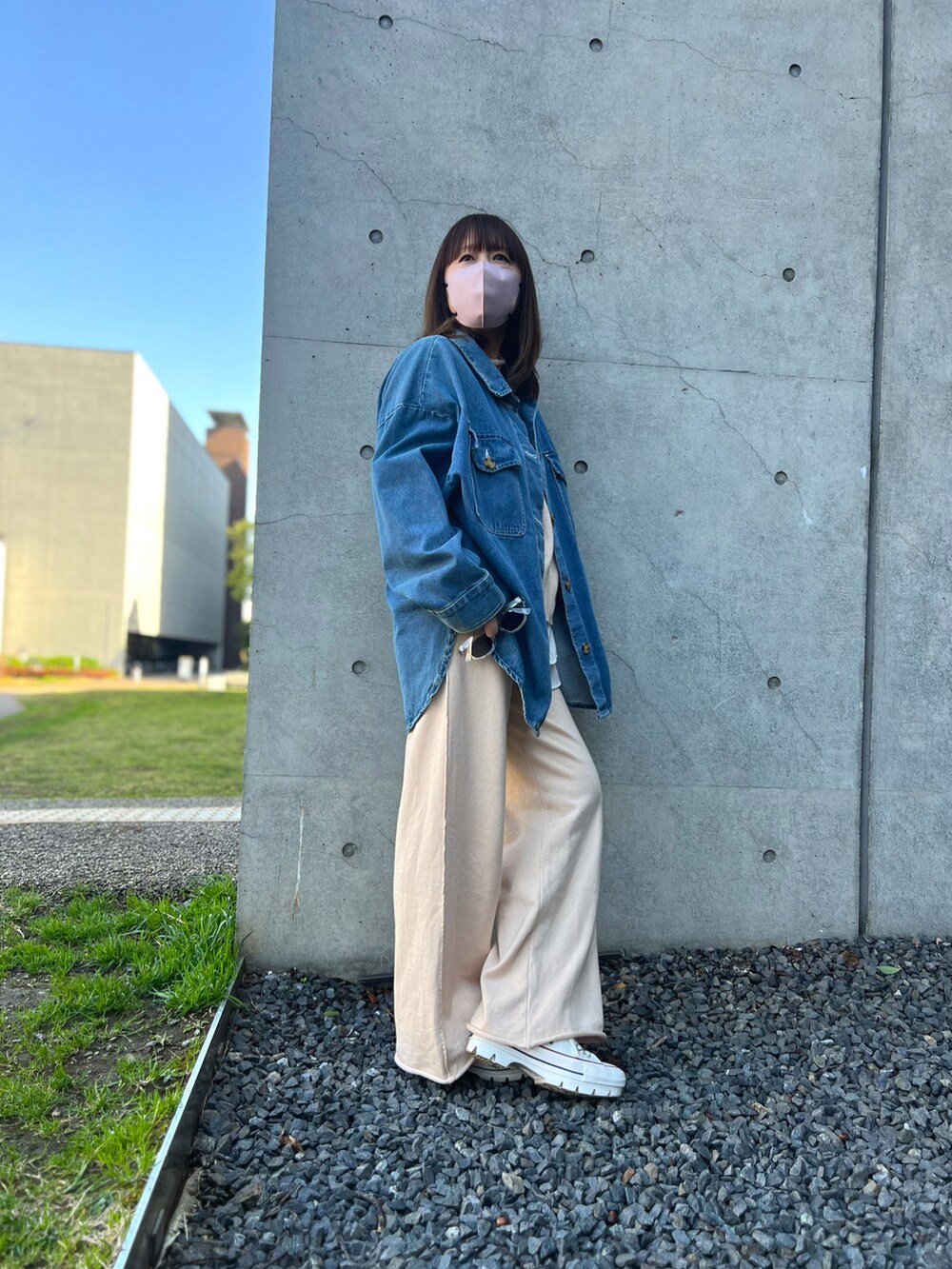 ベージュ系のセットアップ、ホワイト系のスニーカー、ブルー系のデニムジャケットを着用したレディースの冬コーディネートの2枚目の写真