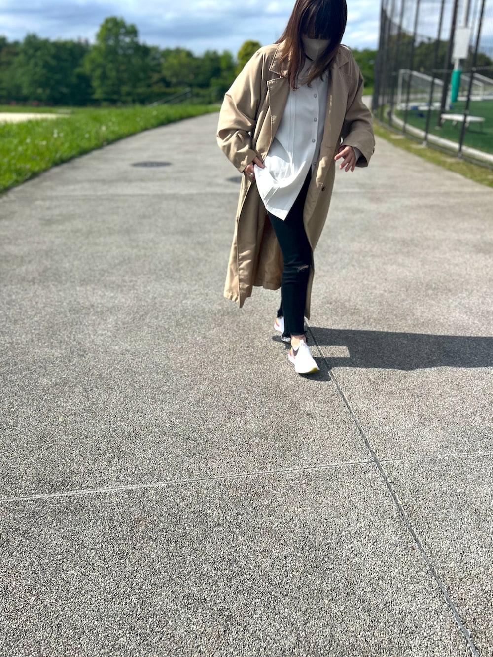 ベージュ系のトレンチコート、ホワイト系のシャツ/ブラウス、ブラック系のデニムパンツを着用したレディースの春コーディネートの3枚目の写真