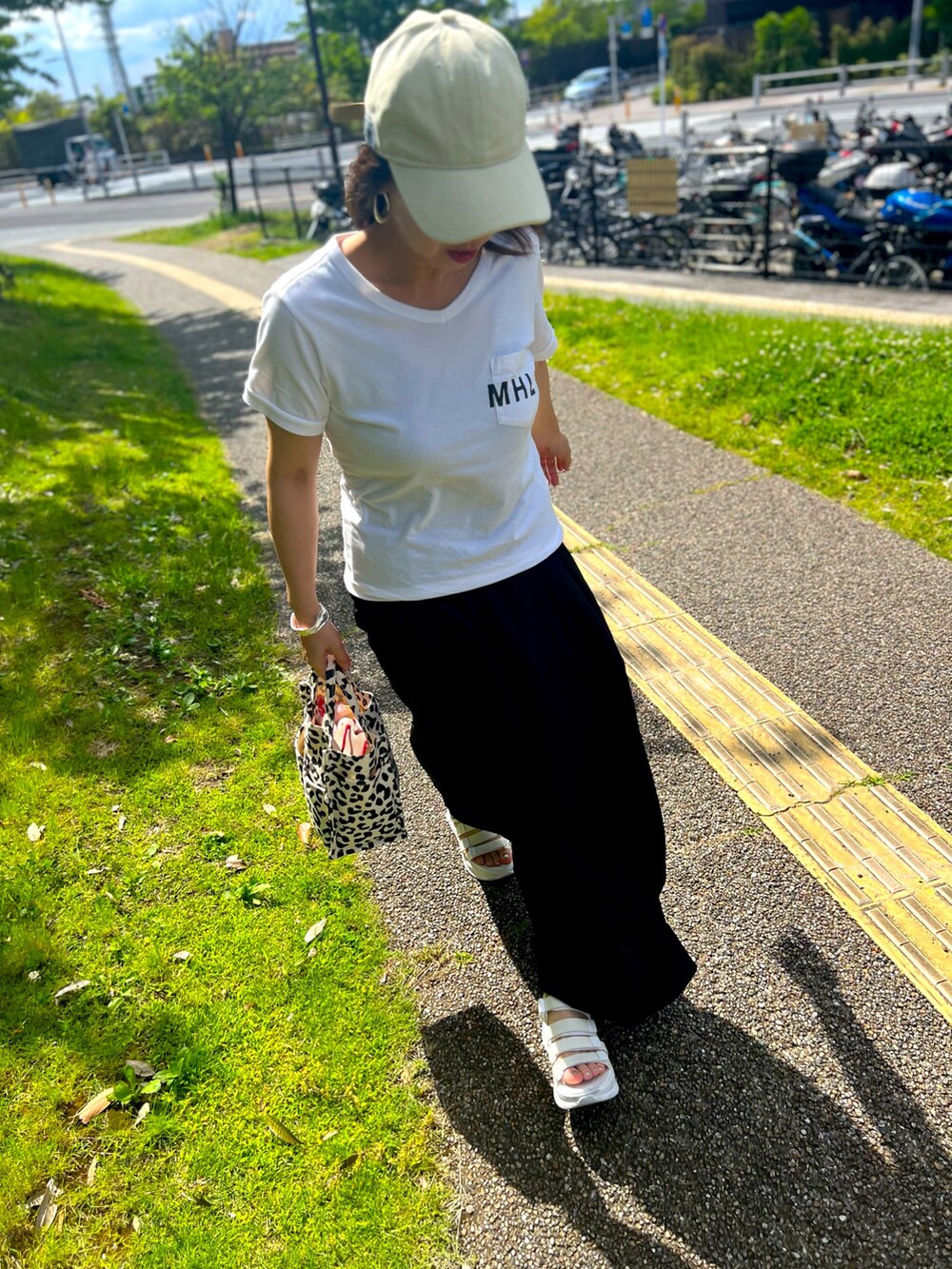 ホワイト系のサンダル、ブラック系のスカート、ホワイト系のTシャツ/カットソーを着用したレディースの夏コーディネートの2枚目の写真