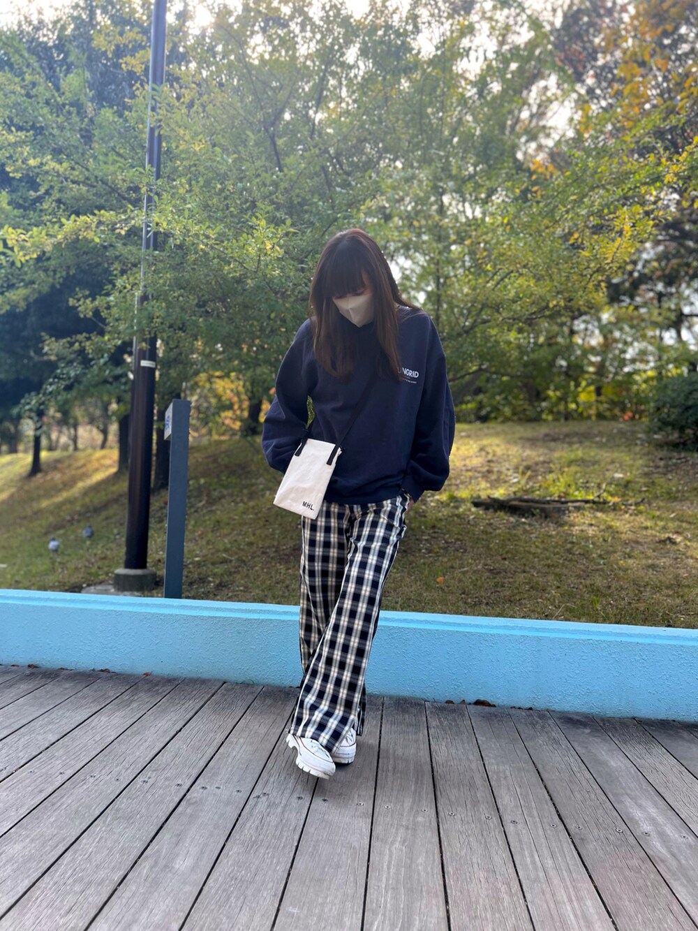 ブルー系のスウェット、ベージュ系のその他パンツ、ホワイト系のスニーカーを着用したレディースの秋コーディネートの3枚目の写真