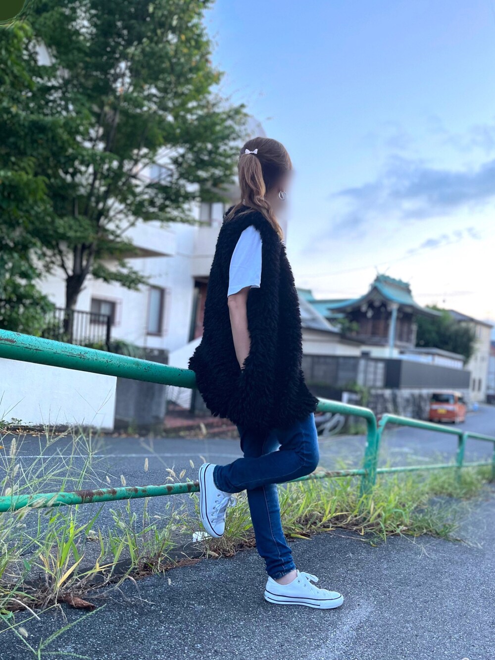 ブラック系のベスト、ホワイト系のTシャツ/カットソー、ブルー系のデニムパンツを着用したレディースの秋コーディネートの2枚目の写真