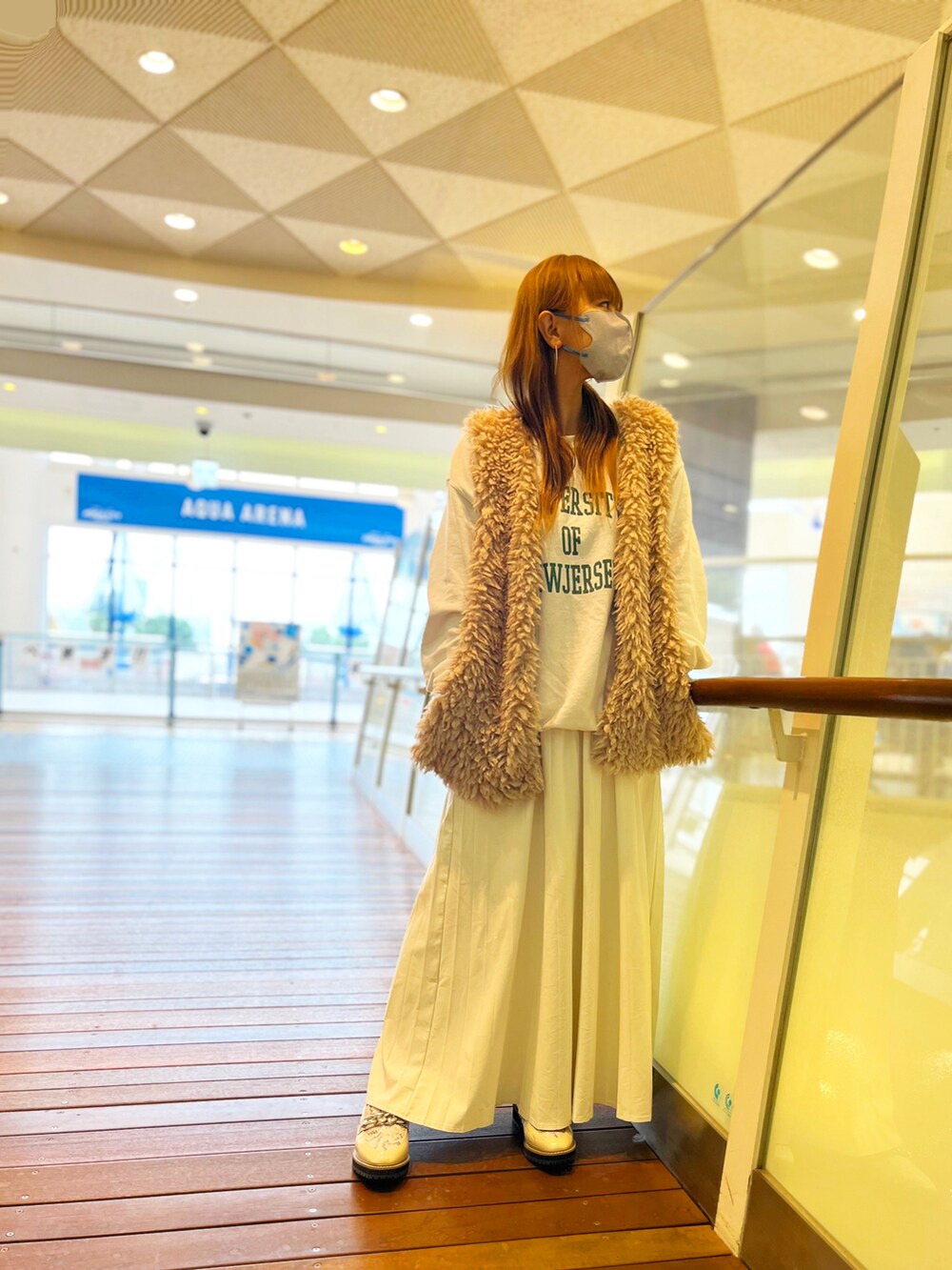 ホワイト系のスウェット、ベージュ系のベスト、ホワイト系のスカートを着用したレディースの冬コーディネートの2枚目の写真