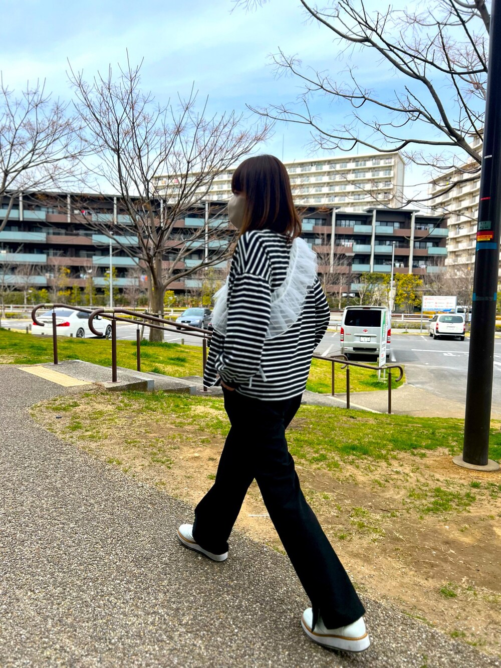 ブラック系のTシャツ/カットソー、ブラック系のその他パンツ、ホワイト系のローファーを着用したレディースの春コーディネートの4枚目の写真