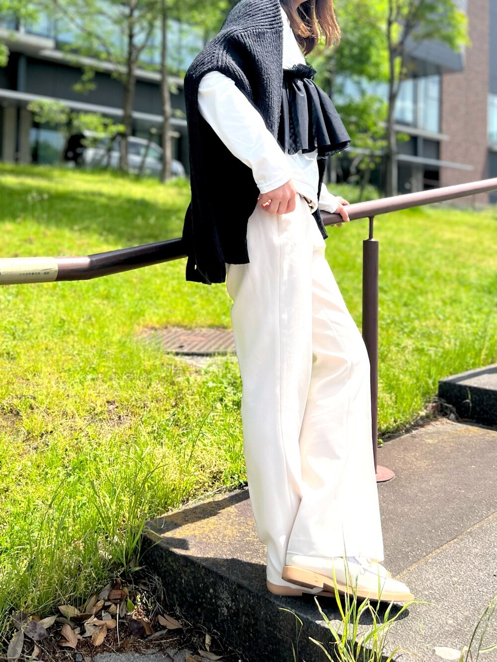 ホワイト系のその他パンツ、ホワイト系のローファー、ブラック系のカーディガン/ボレロを着用したレディースの春コーディネートの2枚目の写真