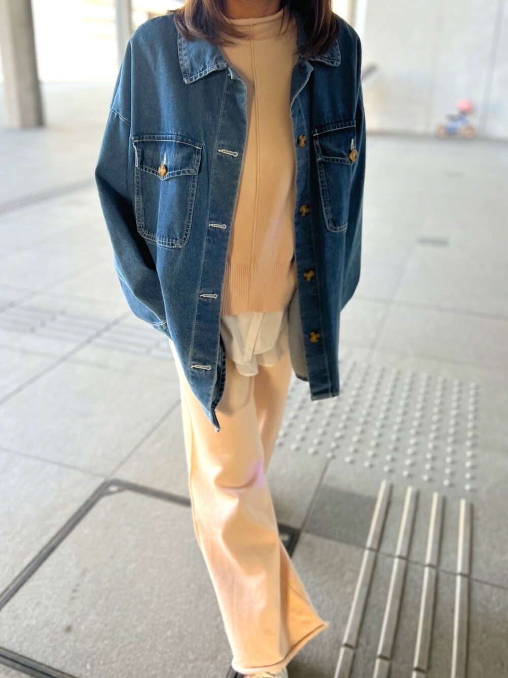 ベージュ系のセットアップ、ホワイト系のスニーカー、ブルー系のデニムジャケットを着用したレディースの冬コーディネートの5枚目の写真